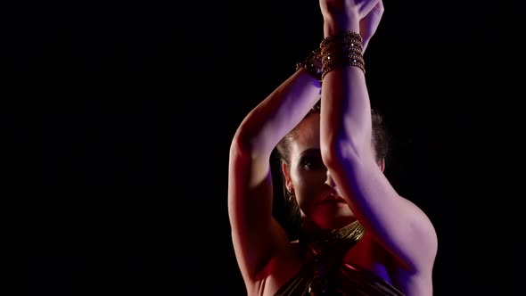 Closeup of a Woman Who Dances an Oriental Dance on a Black Background Makes Beautiful Movements with