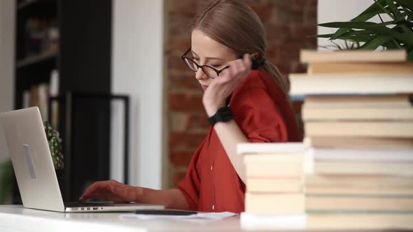 beautiful woman sitting at table and using a mobile phone in her home office