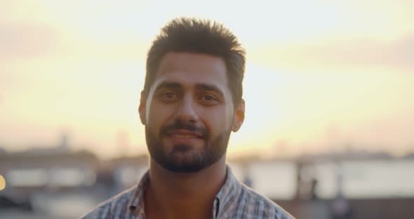 Bokeh Shot of Indian Man Smiling at Camera Standing on Street in Evening