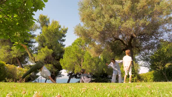 Family Doing Yoga and Relaxation Exercises Outdoors