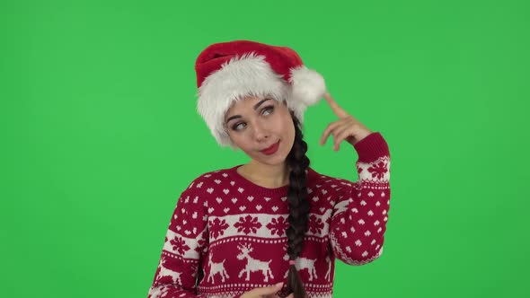 Portrait of Sweety Girl in Santa Claus Hat Is Making Funny Faces. Green Screen