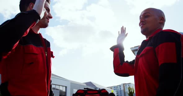 Paramedics giving high five on street