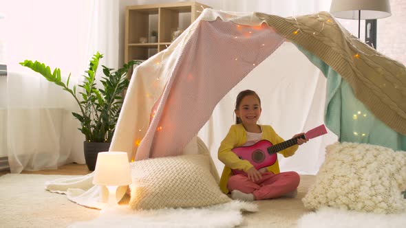 Girl with Toy Guitar Playing in Kids Tent at Home