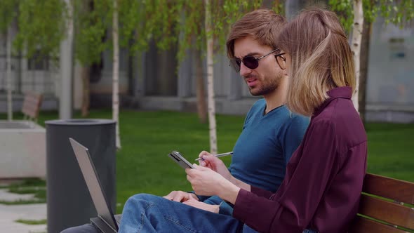 Two professional coworkers discuss and taking notes in clipboard business deals