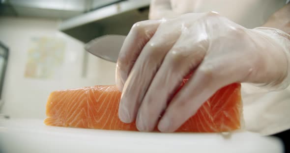 Restaurant Kitchen. Male Sushi Chef Prepares Japanese Sushi Rolls of Rice, Salmon, Avocado and Nori