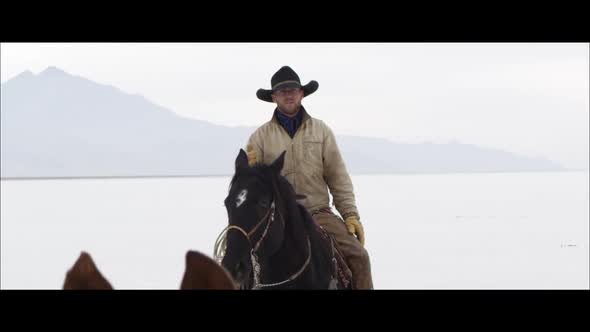 Slow motion wide screen of cowboy on horse back