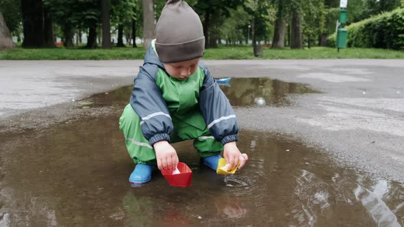 Funny Kid in Rain Boots Playing in a Rain Park