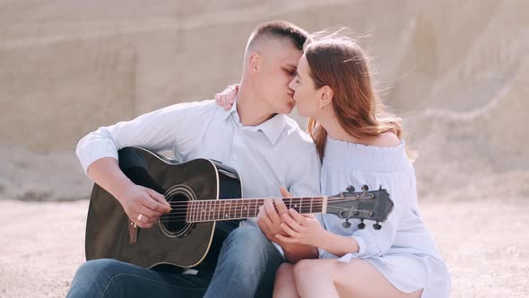 Man Holding Guitar and Woman Kissing in Career in Summer