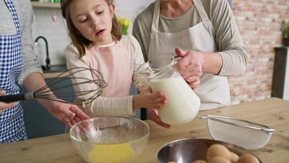 Video of girl helping mother and grandma in the kitchen. Shot with RED helium camera in 8K.