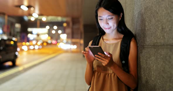 Woman using smart phone in Hong Kong at night 