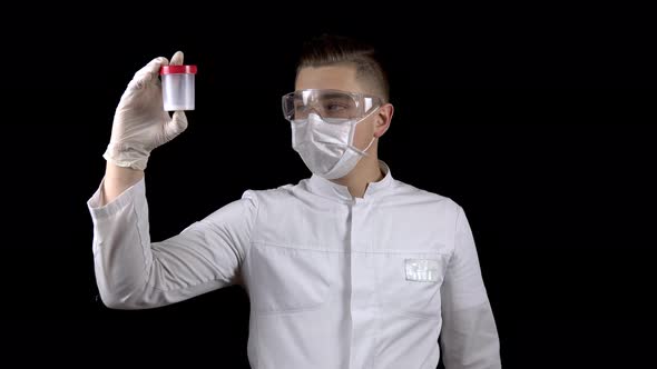 Young Man Doctor Checks Sperm Tests. A Man Examines a Test Jar, Then Shows a Thumb Up. Positive