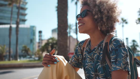 Cheerful sunny African woman talking with her friend and gesturing