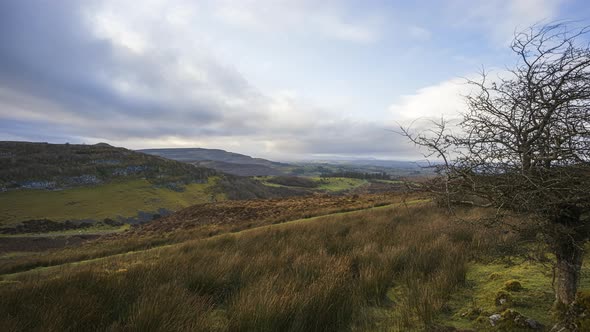 Time lapse of rural and remote landscape of grass, trees and rocks during the day in hills of Carrow