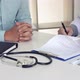 Doctor is signing a medical certificate about the patient's symptoms at the office. - VideoHive Item for Sale