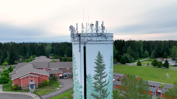 Drone shot of a water tower with technology mounted to the top for broadcasting.