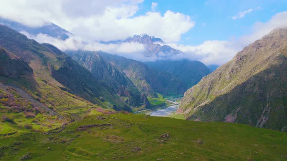 Lovely Mountain Scenery and Sunshine Peaking From Behind the White Clouds