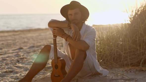 Man With Ukulele During Summer Beach Vacation Near the Sea