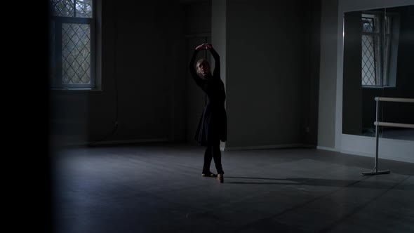 Slim Ballerina in Black Dress Dancing in Darkness Backlit in Studio