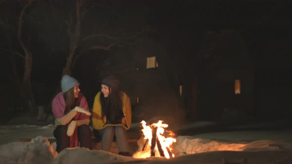 Girls spend time together near fire.