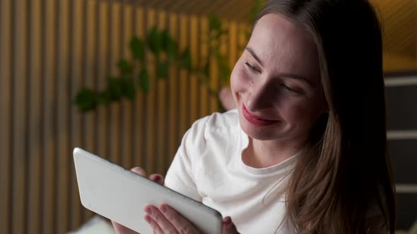 Woman Reads a Blog on a Digital Tablet While Lying in Bed Late at Night