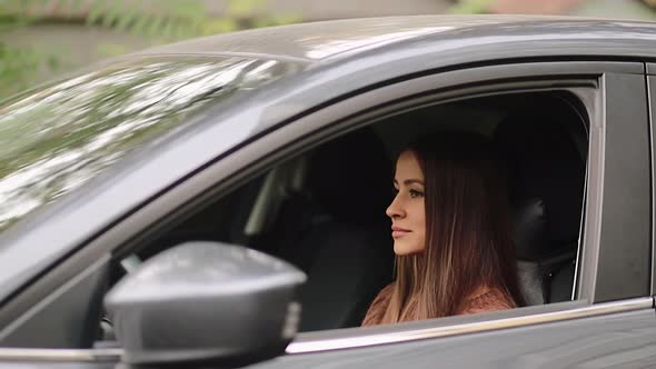 Young woman in car. Auto as present or gift at birthday