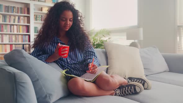 Teen Girl Writes Notes in a Diary Notebook Journal and Writes Down a Todo List