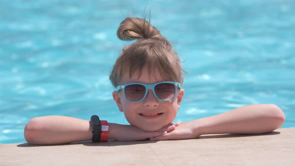 Portrait of Happy Child Girl Relaxing on Swimming Pool Side on Sunny Summer Day During Tropical