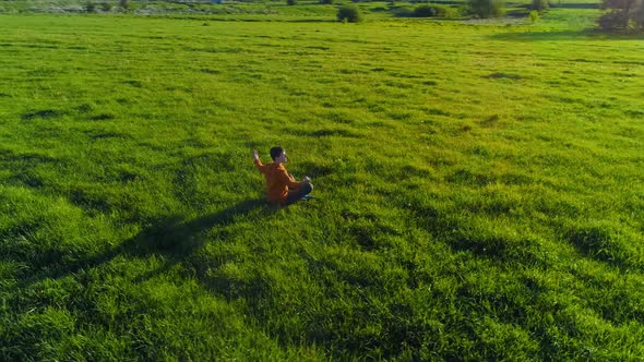 Low Altitude Radial Flight Over Sport Yoga Man at Perfect Green Grass