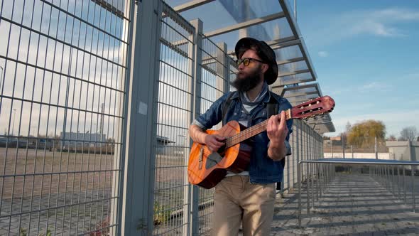 Young Guy Walks in the Sunset Light and Plays the Guitar. Freedom Concept