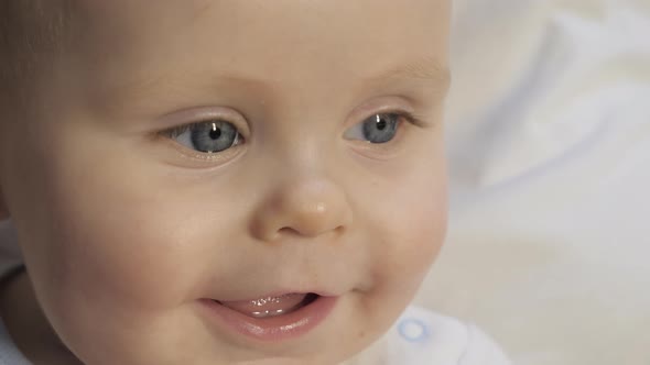 Baby with blue eyes looks at his mother.