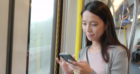 Woman using smart phone on train compartment