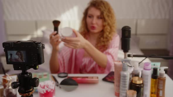 Happy Beautiful Blonde Girl Shows Face Cream to the Camera