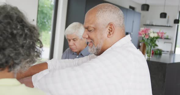 Portrait of happy senior diverse people having dinner at retirement home