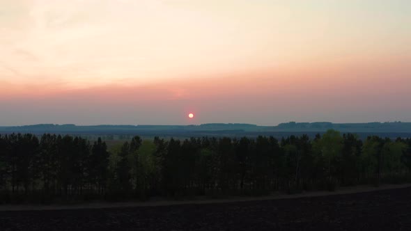 Aerial View of the Red Sunset Over the Forest