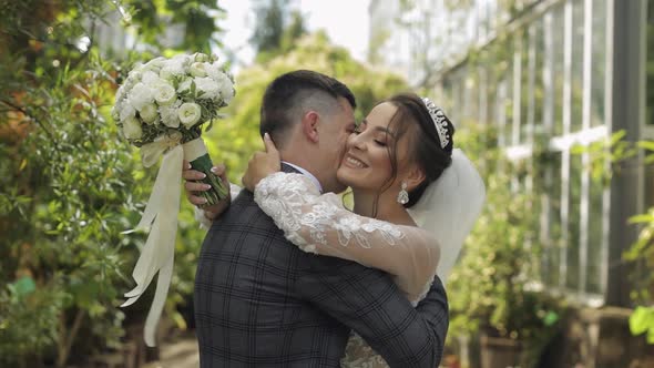 Newlyweds. Caucasian Groom with Bride Walking, Embracing, Hugs in Park. Wedding Couple