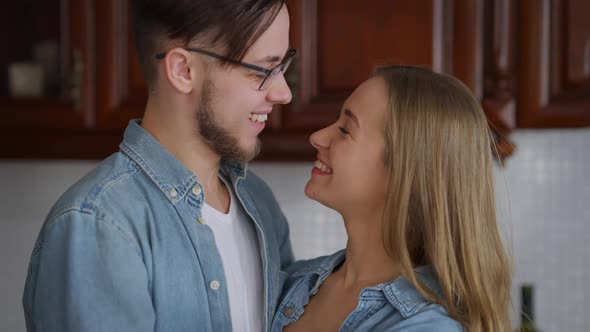 Closeup of Happy Caucasian Young Couple Looking at Each Other with Love Turning to Camera Smiling