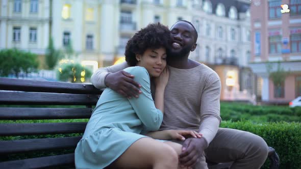 Young African Couple Cuddling on Bench at Sunset, Date in City Park, Closeness