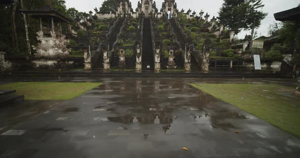 Tilting Dolly Shot of the Puddles at the Base of the Pura Penataran Agung Lempuyang Temple Stairs