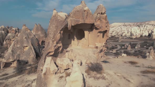 Pull-back, 4k aerial drone footage of the remains of a carved home in Cappadocia of central Turkey