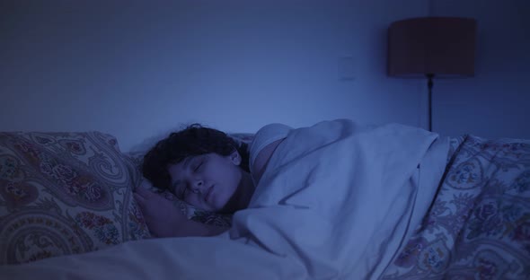 Young woman sleeping at home in bed