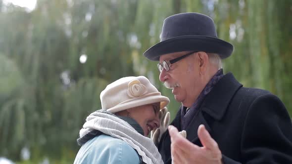 Sweet senior couple dancing in the park.