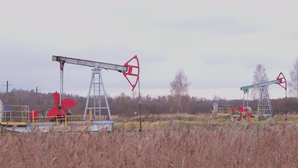 Oil production in Russia. Oil rockers work on the oil field in the autumn.