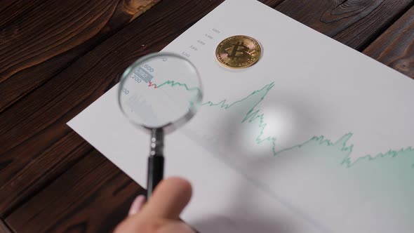 Cryptocurrency Growth Chart and Bitcoin Coin in a Magnifying Glass