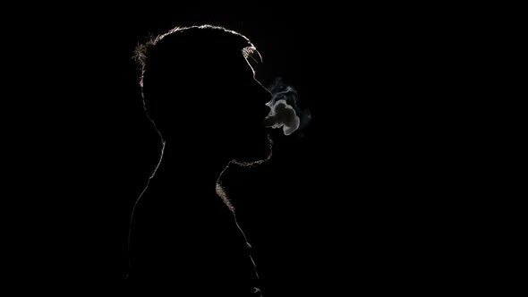 Sad Man Smoking Electronic Cigarette. Black. Silhouette. Slow Motion