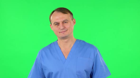 Medical Man Looks at the Camera with Smilling. Green Screen