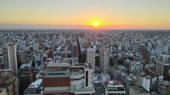 Aerial track right of Belgrano neighborhood buildings and skyscrapers at sunset with bright sun in b