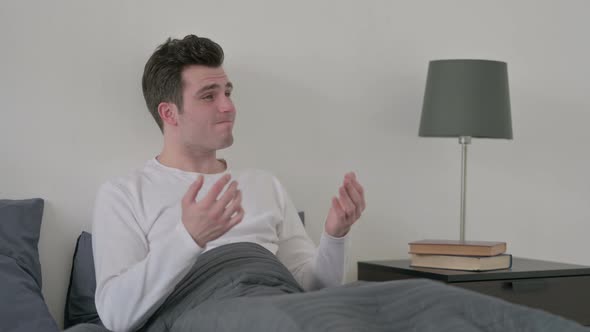 Man Feeling Worried While Sitting in Bed