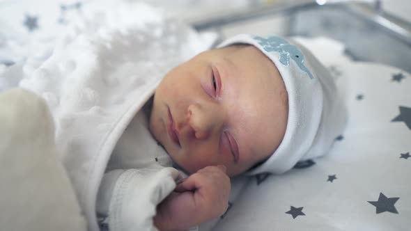 Adorable Newborn Baby Sleeping Peacefully in His Crib in the Hospital Room 