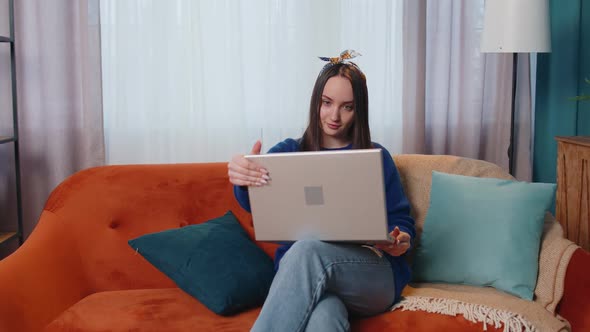 Caucasian Young Woman Sitting on Sofa Opening Laptop Pc Starting Work Online in Living Room at Home