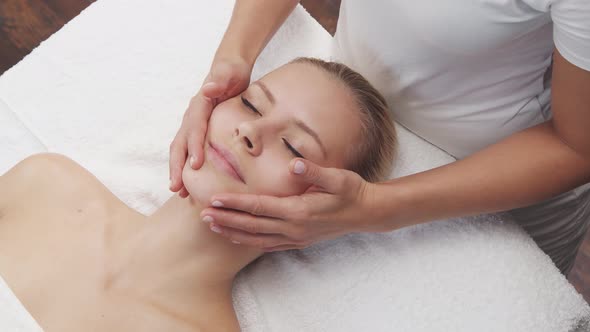 Young, healthy and beautiful woman gets massage therapy in the spa salon.